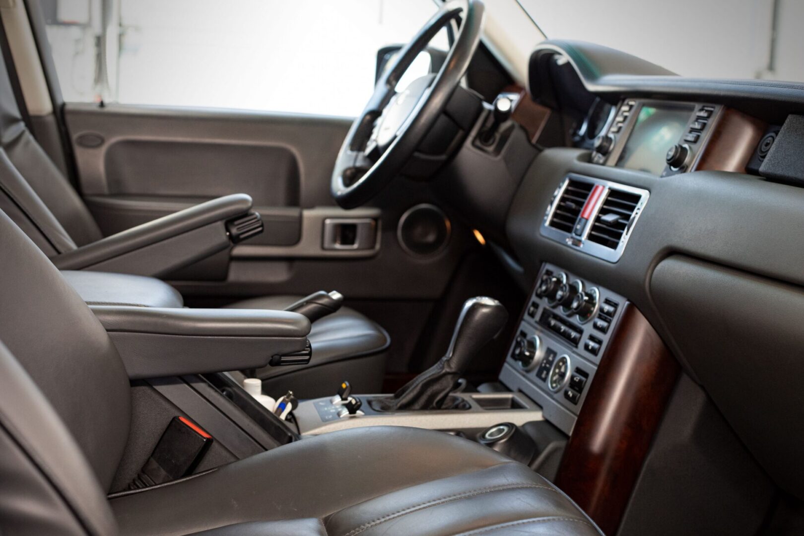 A car 's interior is shown with the steering wheel and dashboard.